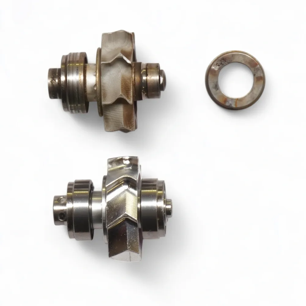 Ein defekter Rotor mit Lagerschaden (Außenring) neben einem neuen Rotorsystem.